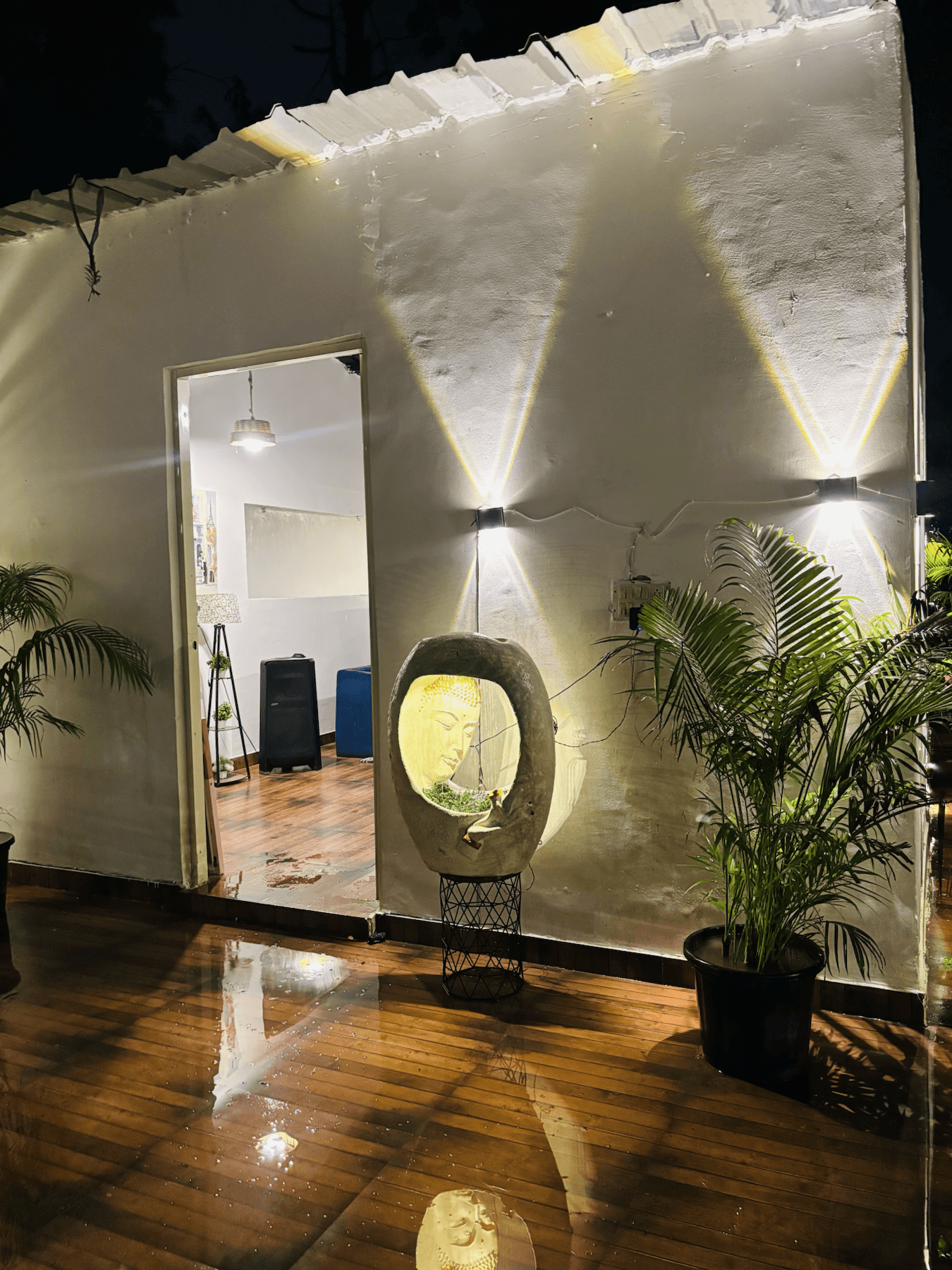Outdoor deck entrance with plants and warm wall lights
