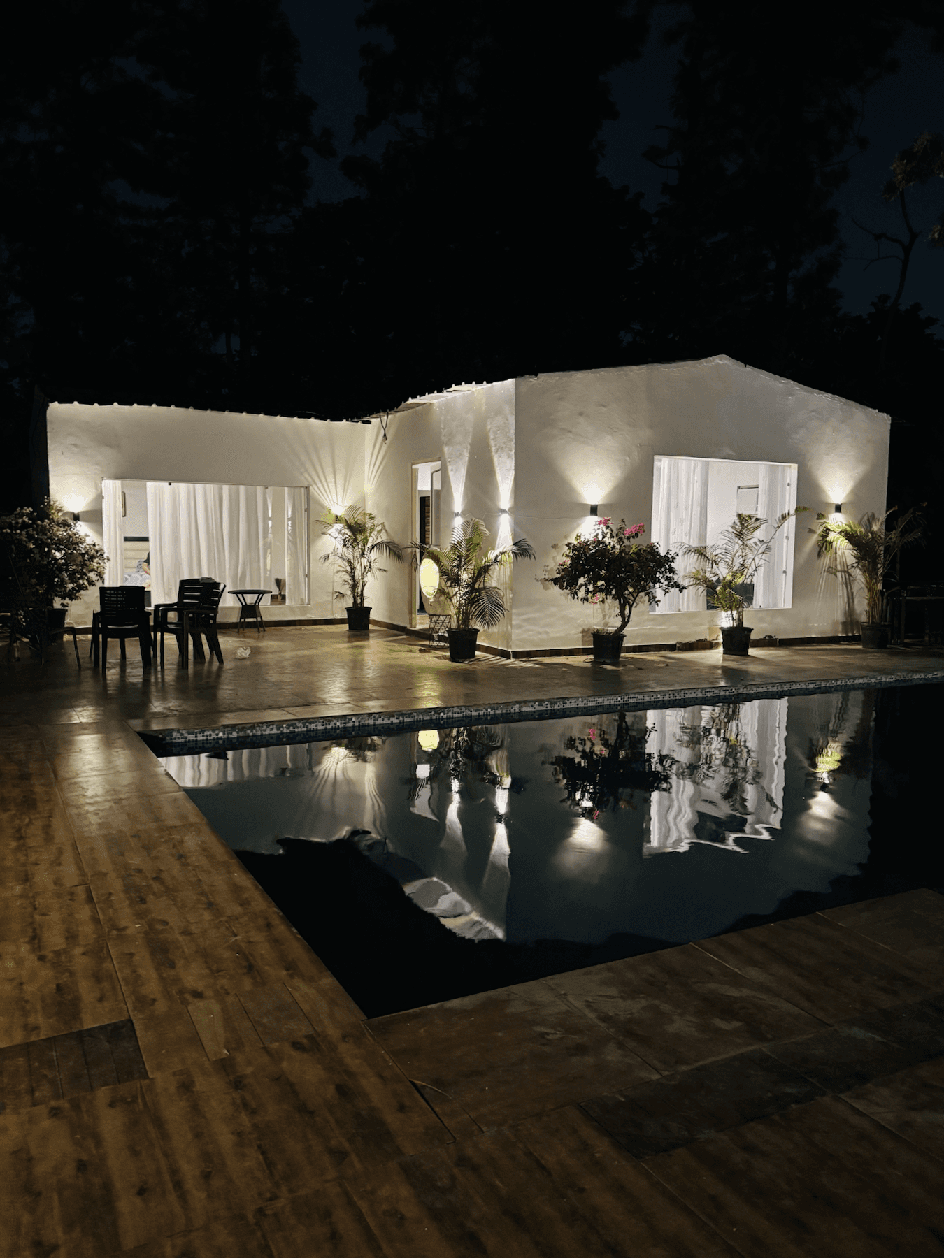 The Cosmos Farm villa lit up beside the pool at night